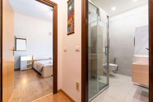 a bathroom with a glass door leading to a bedroom at Arco Park View By Immobilux in Arco