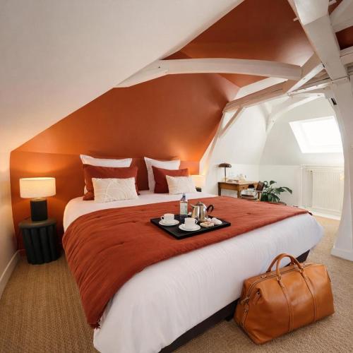 a bedroom with a large bed in an attic at Le Clos Gabrielle in Châtellerault