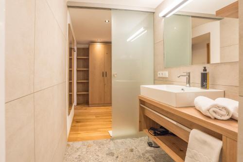 a bathroom with a sink and a mirror at Hotel Kanisfluh in Mellau