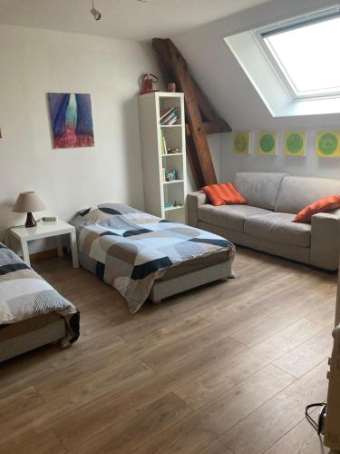 a bedroom with a bed and a couch at Studio à la Ferme in Limpiville