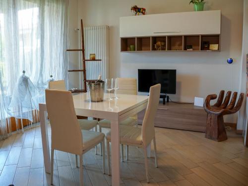a dining room with a white table and chairs at New Home Lazise in Lazise