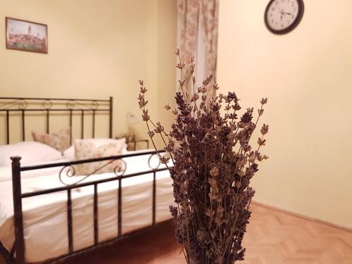 1 dormitorio con 1 cama y un jarrón con flores en Central Square Studios, en Sibiu