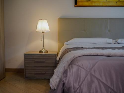 a bedroom with a bed and a lamp on a night stand at New Home Lazise in Lazise