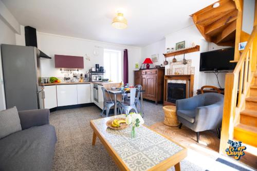 a living room with a table and a kitchen at Le Petit Noirda in Audresselles