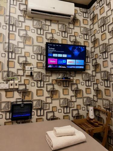a room with a wall with a tv on it at Airi Homestay in Suvarnabhumi Airport