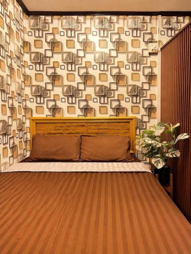 a bed in a room with a wall at Airi Homestay in Suvarnabhumi Airport