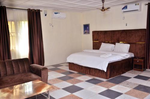 a bedroom with a bed and a couch and a chair at Peace Vil in Kuto