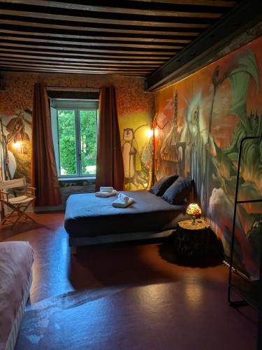 a bedroom with a bed with a painting on the wall at La Tuilerie Du Cinéaste in Courlon