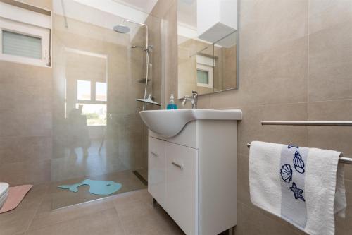 a bathroom with a sink and a shower and a toilet at Apartment Sankovic in Ražanac