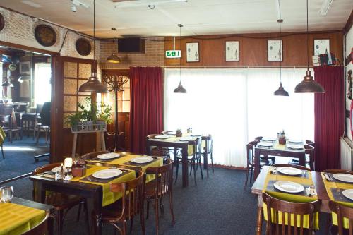 uma sala de jantar com mesas e cadeiras num restaurante em HCR De Tukker em Westdorpe