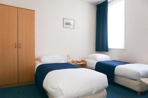 een hotelkamer met 2 bedden en een raam bij HCR De Tukker in Westdorpe