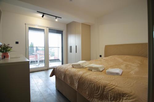 a bedroom with a large bed with towels on it at RiverSide Apartments in Veles