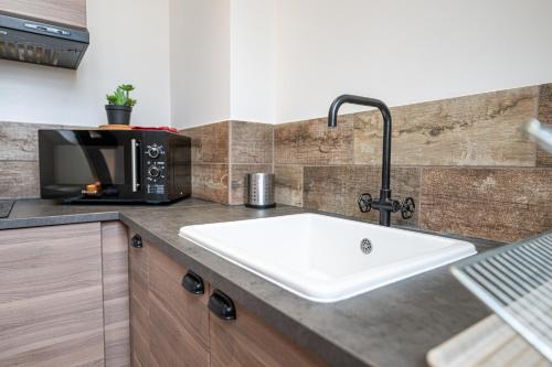 a kitchen counter with a sink and a microwave at Murray - En plein cœur de Caen in Caen