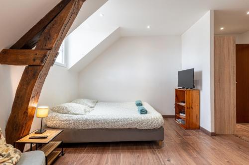 a bedroom with a bed and a tv in it at Murray - En plein cœur de Caen in Caen