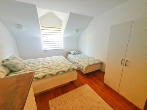 a bedroom with two twin beds and a window at Villa Riverside Haven in Hadžići