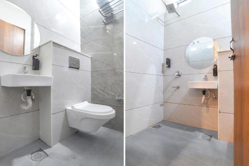 a bathroom with a toilet and a sink and a mirror at FabHotel Trivana, Mahalaxmi Nagar in Indore