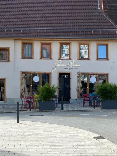 a building with tables and chairs in front of it at Josis Klause Café I Pension in Albstadt