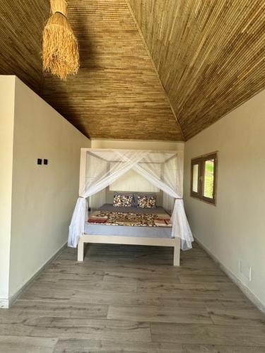 a bed in a room with a wooden ceiling at Toubakouta River Paradise in Toubakouta