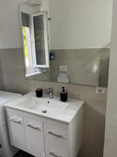 a bathroom with a white sink and a mirror at Casa Vacanza Giorgio Apartment in Gallarate