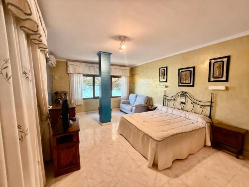 a bedroom with a bed and a couch at Hotel Entrelagos in Ruidera