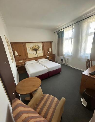 a hotel room with two beds and a table at Hotel Braník in Prague
