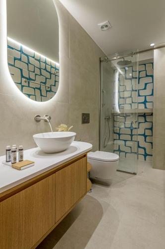a bathroom with a sink and a toilet and a mirror at Dawn Milos in Pollonia