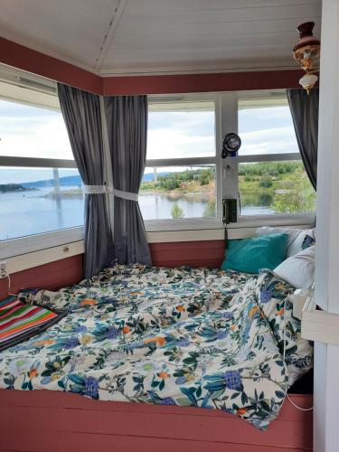 a bed in a room with a window at Kystbua 360 in Saltstraumen