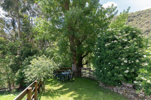 a garden with a table and chairs under a tree at Fidalsa Paradise Point in Cabezón de Liébana