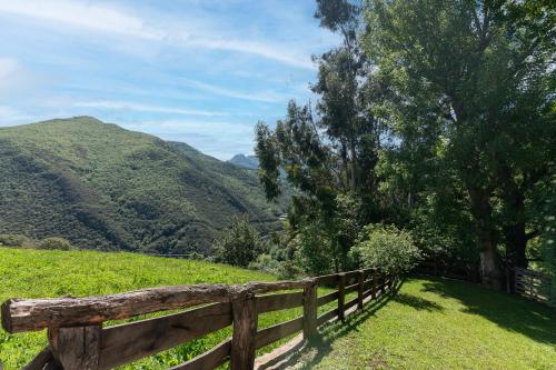 a wooden fence in a field with mountains in the background at Fidalsa Paradise Point in Cabezón de Liébana