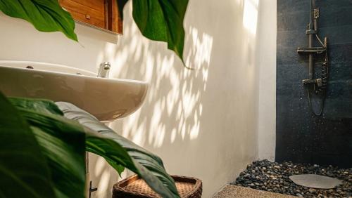 a bathroom with a sink and a plant at eM eR GLAMPING & VILLAS in Bedugul