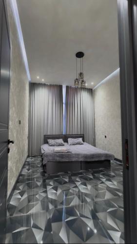 a bedroom with a bed and a chandelier at Palm Villa in Mərdəkan