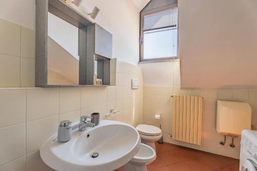 a bathroom with a sink and a toilet and a mirror at Piazza Michele Ferrero - sulla piazza centrale in Alba