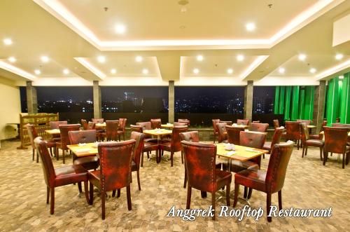 a restaurant with tables and chairs in a room at Green Batara Hotel in Bandung