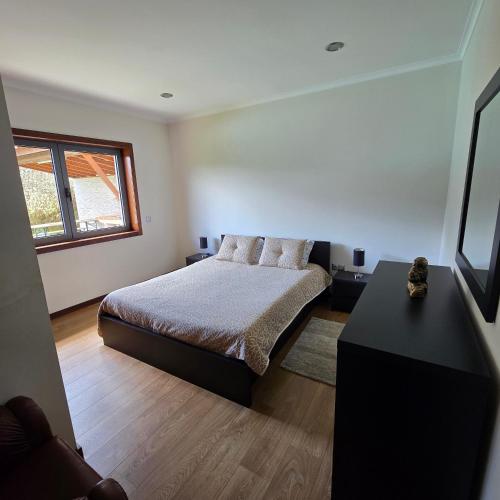 a bedroom with a bed and a window at Casa da Batoca - Rossas in Vieira do Minho