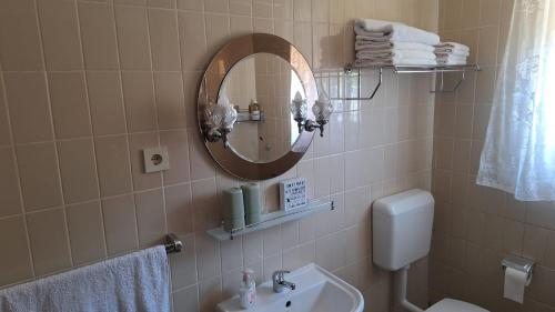 a bathroom with a sink and a mirror and a toilet at Lake Crown in Ogulin
