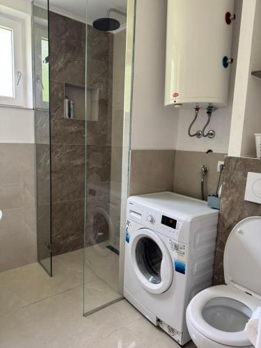 a bathroom with a washing machine and a toilet at Apartmani Sweet Dreams in Banja Luka