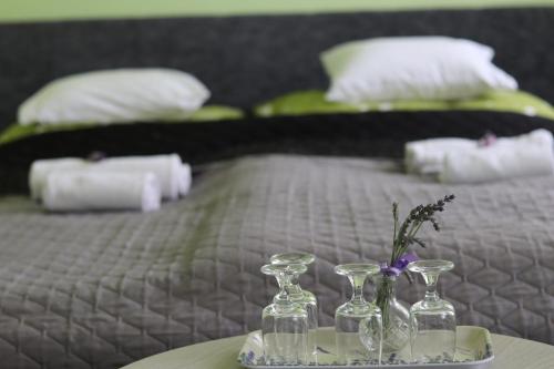 a bed with a table with two glassases on it at Levendula Vendégház - Bezi in Bezi