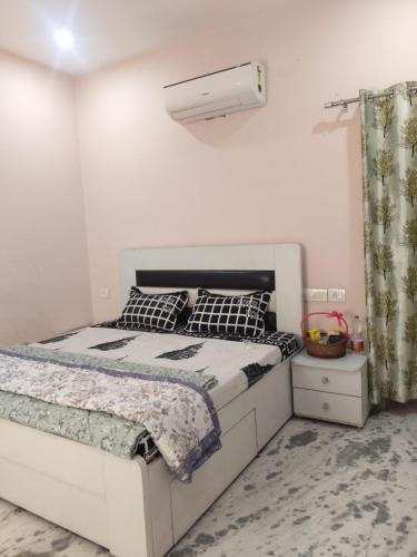 a bedroom with a white bed and a lamp at Om Homestay in Panchkula