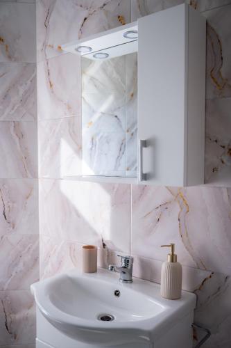 a white bathroom with a sink and a mirror at Breb 155 in Breb