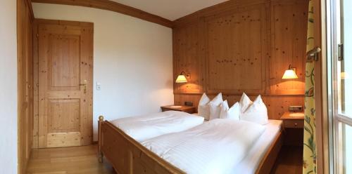 a bedroom with a large bed with white sheets at Wellnessappartements Margit in Alpbach