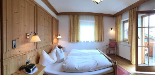 a hotel room with a bed and a window at Wellnessappartements Margit in Alpbach