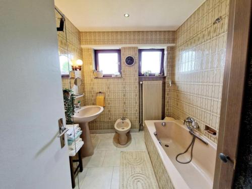 a bathroom with a tub sink and a toilet at Gite Les Ptits Biscuits in Vittersbourg
