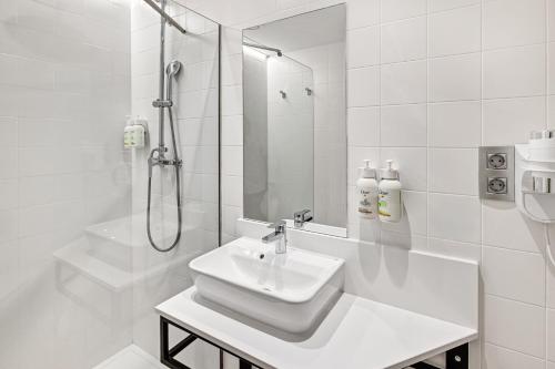 ein weißes Badezimmer mit Waschbecken und Dusche in der Unterkunft B&B HOTEL Granada in Pulianas
