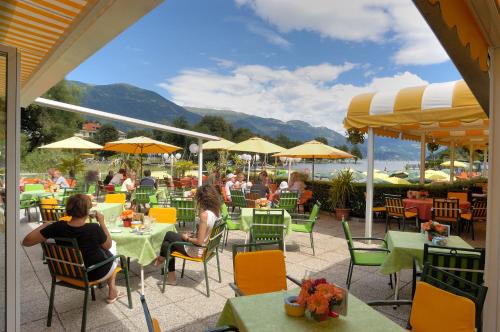 a group of people sitting at tables at a restaurant at Seehotel Steiner in Seeboden