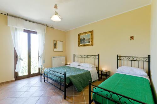 a bedroom with two beds and a window at Casale Rustico ColleBello in Castiglione Messer Raimondo