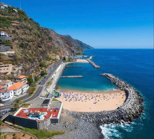 an aerial view of a beach with people in the water at Meu Quintal 3, Calheta-Madeira in Calheta