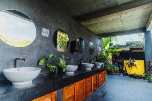 a bathroom with three sinks and two mirrors at Che Puerto Escondido Hostel & Bar Adults Only in Puerto Escondido