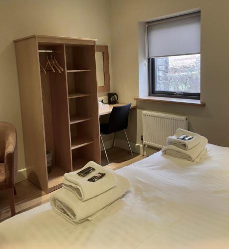 a bedroom with two towels sitting on a bed at Nant Gwrtheyrn in Llithfaen