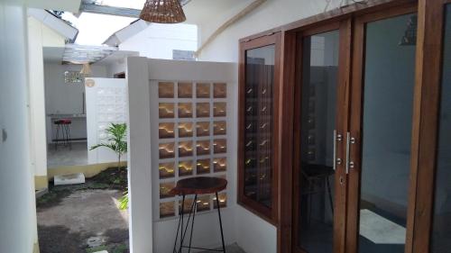 a wine cellar with a stool in front of a glass door at Datang Kemari Bungalow in Gili Islands