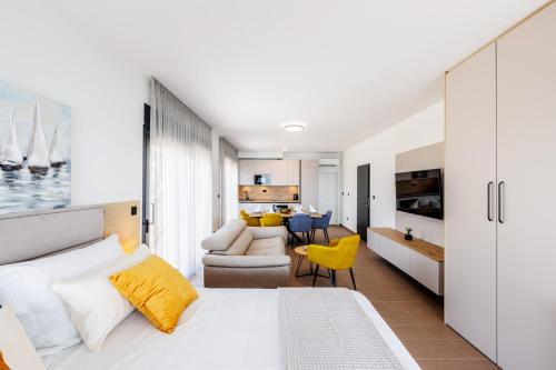 a bedroom with a white bed and a living room at Stella Maris in Podstrana